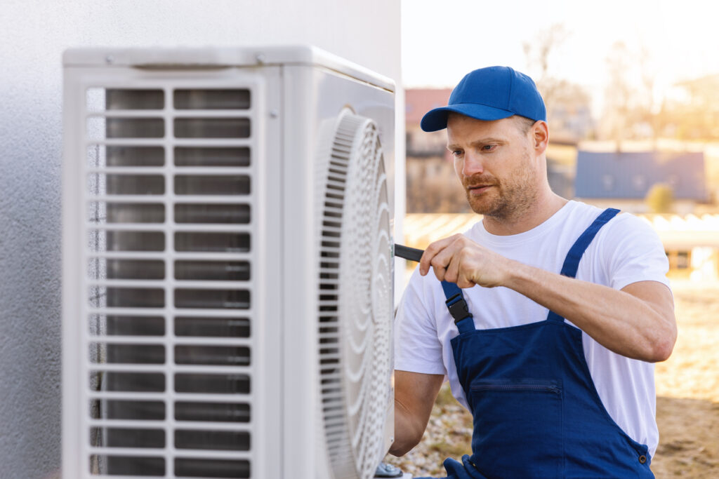 HVAC technician repairing a heat pump