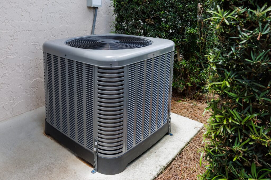 Well-maintained outdoor air conditioning unit beside a home serviced by Dowd Heating & Air Conditioning during routine AC maintenance.