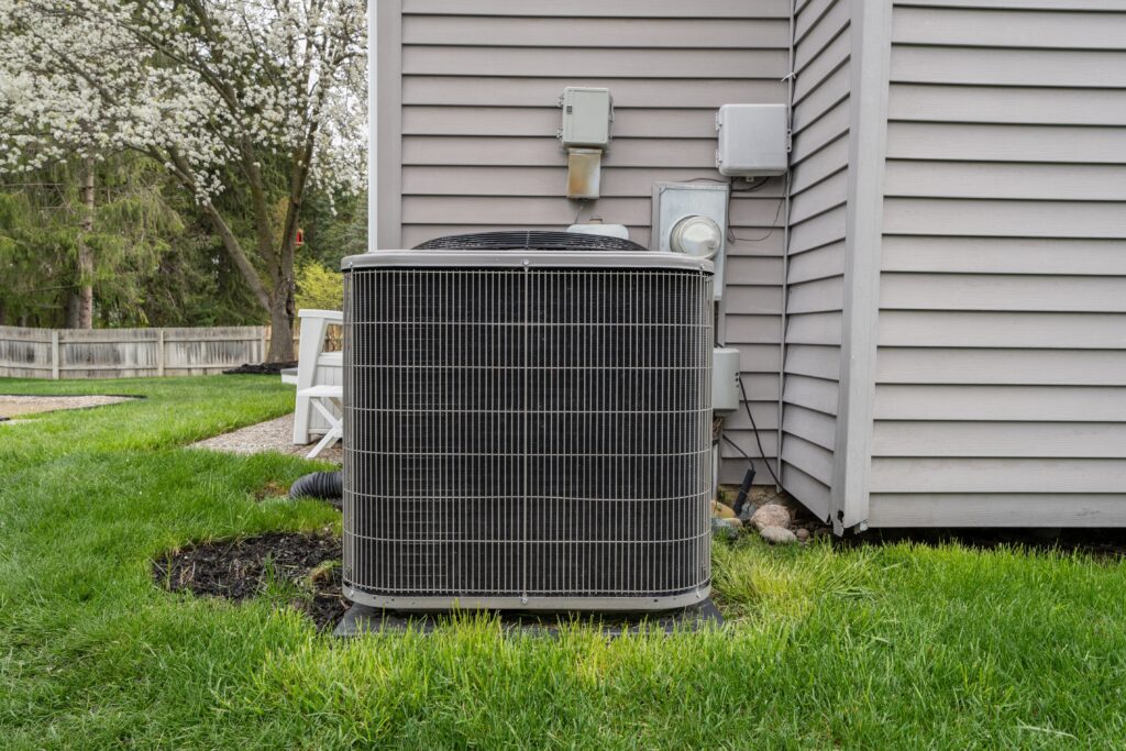 Outdoor residential air conditioning condenser unit installed beside a home by Dowd Heating & Air Conditioning for reliable cooling performance.