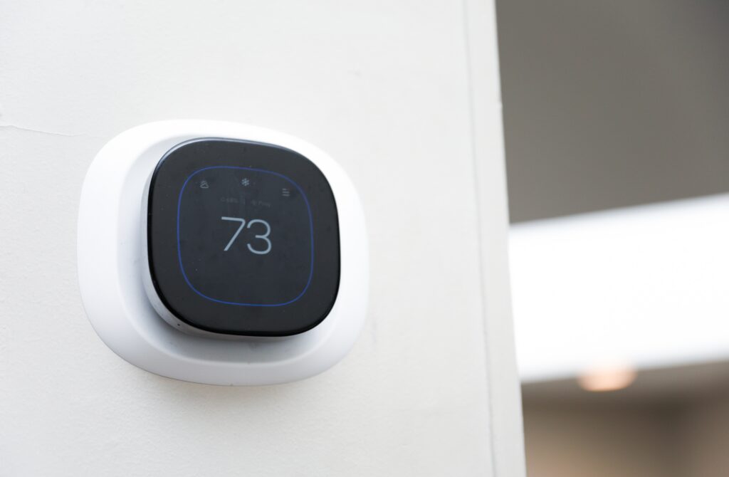 Smart thermostat mounted on an interior wall displaying temperature settings for home comfort control